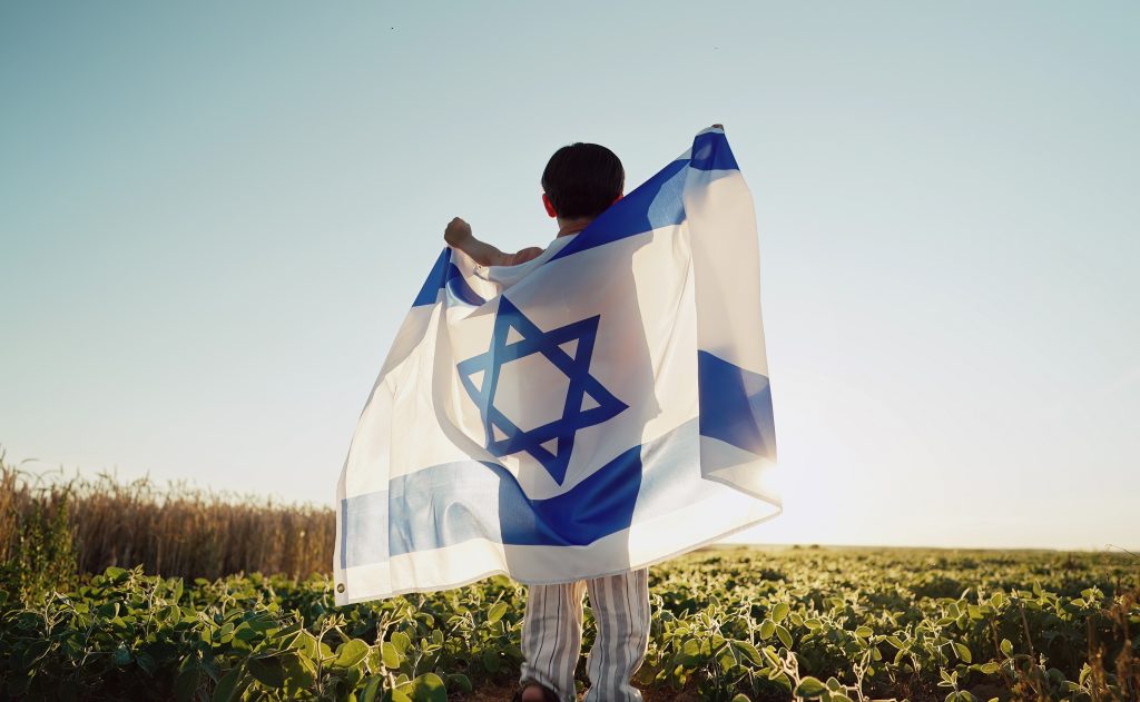 Happy,Israeli,Jewish,Little,Boy,Jumping,,Israel,National,Flag.,Independence - StandWithUs